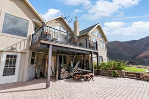 Back of house featuring a patio area, a mountain view, and a balcony