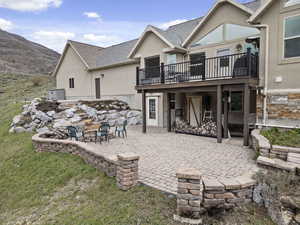 Back of property featuring a patio area, an outdoor fire pit, and a mountain view