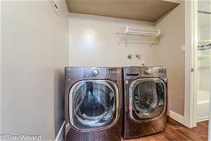 Laundry area featuring separate washer and dryer and hardwood / wood-style flooring