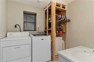 Washroom featuring sink, electric dryer hookup, and separate washer and dryer