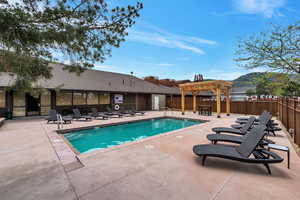 View of swimming pool with a patio area and a pergola