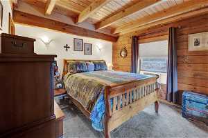 Bedroom featuring beamed ceiling, wooden ceiling, and carpet floors