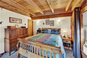 Carpeted bedroom featuring wood ceiling and beam ceiling