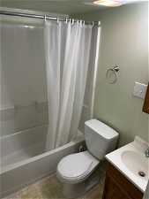 Full bathroom featuring vanity, toilet, tile floors, and shower / bath combo with shower curtain