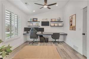 Office featuring lofted ceiling, light hardwood / wood-style flooring, ceiling fan, and built in desk