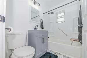Full bathroom featuring toilet, tile flooring, vanity, and bathtub / shower combination