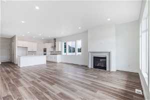 Unfurnished living room with sink and light hardwood / wood-style floors