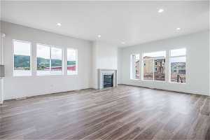 Unfurnished living room with a wealth of natural light and hardwood / wood-style floors