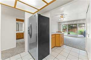 Kitchen featuring light colored carpet, stainless steel refrigerator with ice dispenser, and ceiling fan