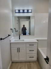 Master Bathroom with a tub to relax in, vanity, and hardwood / wood-style floors