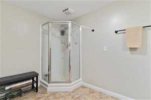 Bathroom with a shower with shower door and tile flooring