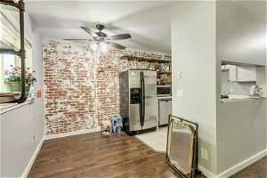 Kitchen with ceiling fan, light hardwood / wood-style flooring, stainless steel appliances, and brick wall