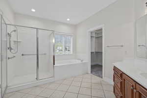 Master Bathroom featuring independent shower and bath, tile flooring, and vanity