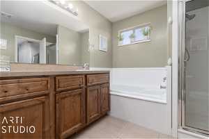 Bathroom with tile flooring, independent shower and bath, and oversized vanity