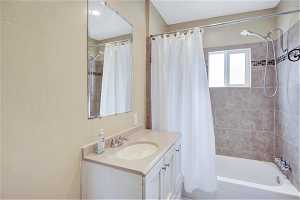 Bathroom with shower / bath combination with curtain and large vanity