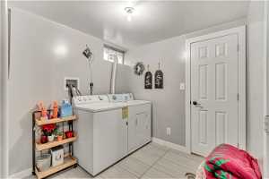 Laundry room featuring independent washer and dryer and light tile flooring