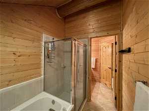 Bathroom with wood ceiling, a bath to relax in, wood walls, and tile flooring