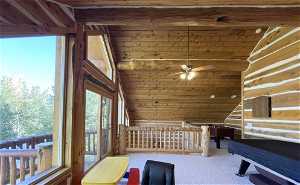 Interior space with carpet flooring, wooden ceiling, ceiling fan, and vaulted ceiling