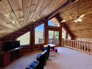 Interior space featuring wood ceiling, a healthy amount of sunlight, carpet, and vaulted ceiling