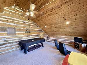 Interior space with log walls, pool table, lofted ceiling, carpet flooring, and wooden ceiling