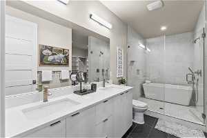 Bathroom with walk in shower, double vanity, tile flooring, and toilet