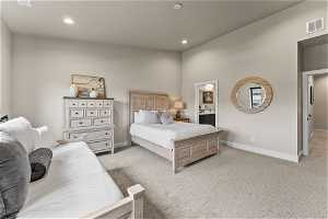 Bedroom featuring light colored carpet and connected bathroom