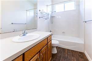 Full bathroom featuring shower / washtub combination, hardwood / wood-style flooring, toilet, and vanity