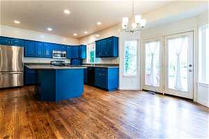 Kitchen featuring a center island, dark hardwood / wood-style flooring, blue cabinetry, and stainless steel appliances