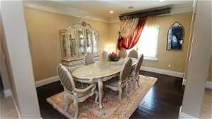 Formal dining space with engineering hardwood floors and ornamental molding