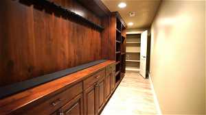 Gun room and Media room closet with Luxury Vinyl Plank (LVP) flooring and dark cabinets