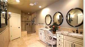 Basement bathroom with tile flooring, double vanity, and an enclosed shower