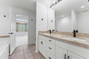 Master Bathroom with dual sinks, seperate shower & tub, and double sink vanity