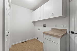 Laundry area featuring cabinets, hookup for an electric dryer, washer hookup.