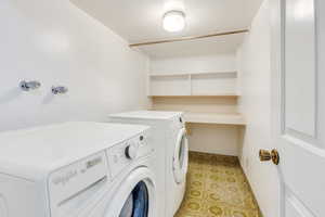 Washroom with washing machine and dryer and groovy tile floors