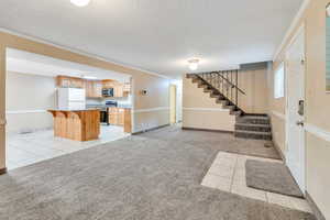 ADU: Tiled foyer with a textured ceiling and crown molding, and new carpet