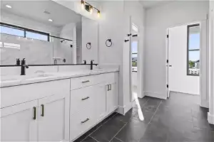 Bathroom with a shower with door, a healthy amount of sunlight, tile floors, and dual bowl vanity
