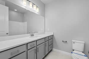 Bathroom featuring tile floors, vanity, and toilet