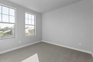 Carpeted empty room featuring plenty of natural light