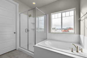 Bathroom with a healthy amount of sunlight, tile floors, and independent shower and bath