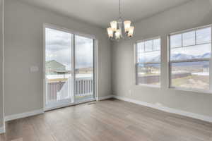 Empty room with an inviting chandelier and light wood-type flooring