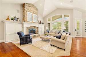 Living room with light hardwood / wood-style floors, a fireplace, and a wealth of natural light