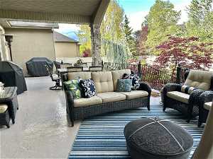 View of covered deck with an outdoor living space and grilling area