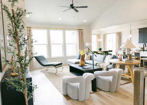 Living room with ceiling fan, light hardwood / wood-style flooring, and high vaulted ceiling