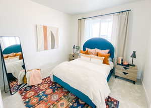 Bedroom featuring light colored carpet