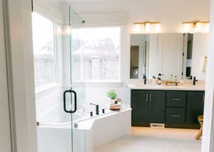 Bathroom featuring vanity, tile patterned flooring, and shower with separate bathtub