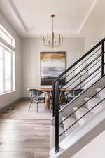 Dining room featuring a raised ceiling, hardwood / wood-style floors, and a notable chandelier