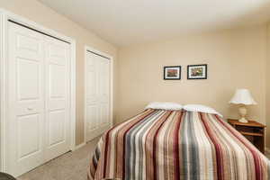 Bedroom featuring two closets and carpet flooring