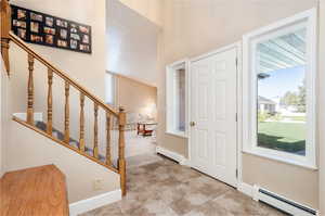 Entrance foyer featuring a baseboard heating unit and light tile floors