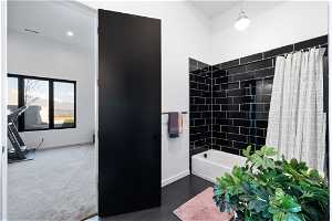 Bathroom featuring tile floors and shower / tub combo with curtain