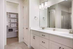 Bathroom featuring vanity with extensive cabinet space, double sink, an enclosed shower, and tile flooring